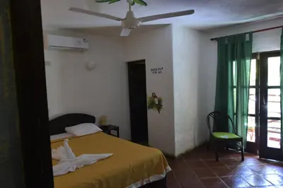 a bedroom with a bed and a ceiling fan at Hotel El Rancho Sosua in Sosúa