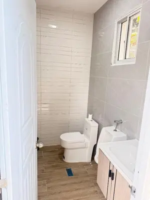 a white bathroom with a toilet and a sink at VILLA LEMON Samaná in El Limón