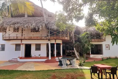 a house with a thatched roof and a patio at Coco's Apartment near La Playita beach in Las Galeras