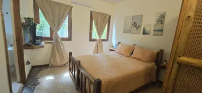 a bedroom with a bed in a room with windows at Coco's Apartment near La Playita beach in Las Galeras