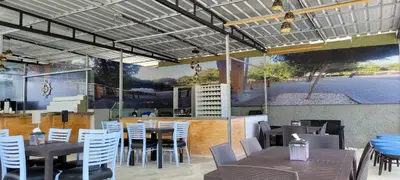 a restaurant with tables and chairs and a large mural at Room 6 in Río San Juan