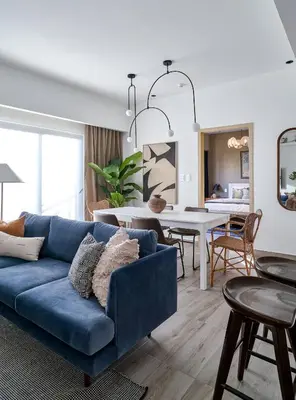 a living room with a blue couch and a dining room at Regatta Living Suites by Yellowkey in Santo Domingo