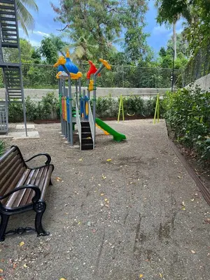 a park with a playground with a slide and a bench at Escapada perfecta, apartamento frente al mar in San Felipe de Puerto Plata