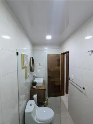 a white bathroom with a toilet and a sink at Escapada perfecta, apartamento frente al mar in San Felipe de Puerto Plata