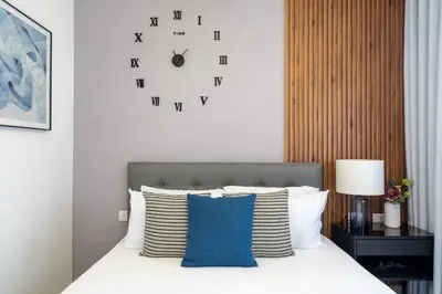 a bedroom with a bed with a clock on the wall at Splendid-KingBed-3BR-Pool-AC-Modern-WiFi-Yellowkey in Santo Domingo