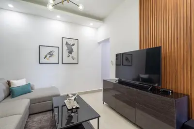 a living room with a couch and a flat screen tv at Splendid-KingBed-3BR-Pool-AC-Modern-WiFi-Yellowkey in Santo Domingo