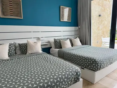 a bedroom with two beds and a blue wall at Golf 218 Playa Nueva Romana in San Pedro de Macorís