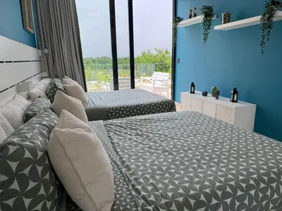 two beds in a bedroom with blue walls at Golf 218 Playa Nueva Romana in San Pedro de Macorís