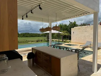 a kitchen with a table and chairs and a pool at Golf 218 Playa Nueva Romana in San Pedro de Macorís