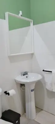 a white bathroom with a sink and a mirror at Room 1 in Río San Juan