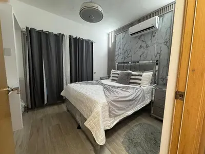 a bedroom with a bed and a wall at Lujoso townhouse en Boca Chica in Boca Chica