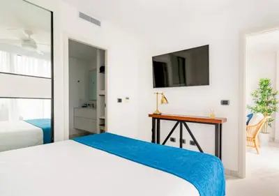 a bedroom with a bed and a desk and a tv at Cana Rock Star in Punta Cana