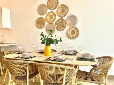 a dining room with a table with chairs and plates at Peaceful 2BR 2BA in Bonita with Pool and Palm Tree Views in Las Terrenas