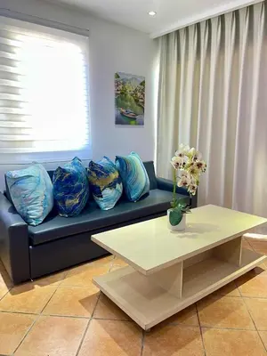 a living room with a blue couch and a table at Sea front apartment, Juan Dolio, San Pedro in San Pedro de Macorís