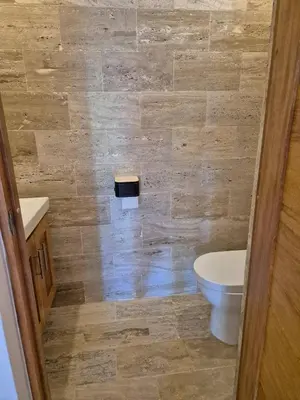 a bathroom with a toilet and a tiled wall at Punta Popy 3BR Duplex with Pool, Walk to Beach in Las Terrenas