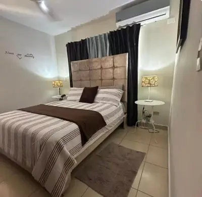 a bedroom with a large bed and a table at Acogedor apartamento en la Jacobo majcluta in Jacagua