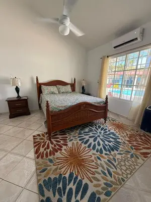 a bedroom with a bed and a rug at Villa Las Tortugas # 2 in Sousa in Sosúa