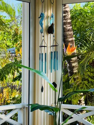 a window with two windmills and a plant at Romantic Beachfront Retreat In Las Terrenas - Everything You Could Want - 2 Rooms in Las Terrenas
