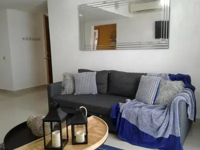 a living room with a gray couch and a table at Apartamento en Boca Chica T1 610 in Boca Chica