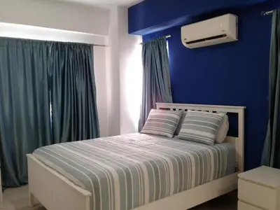 a bedroom with a bed with a blue wall at Apartamento en Boca Chica T1 610 in Boca Chica