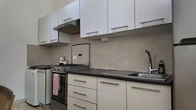 a kitchen with white cabinets and a sink at La Fenice Beachfront Apartment in Las Terrenas