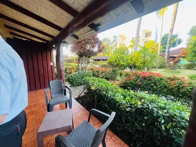 a porch with chairs and a garden with flowers at Hotel palococo in Las Terrenas