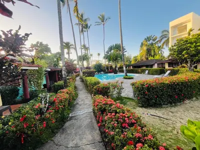 a garden with flowers and a swimming pool at Hotel palococo in Las Terrenas