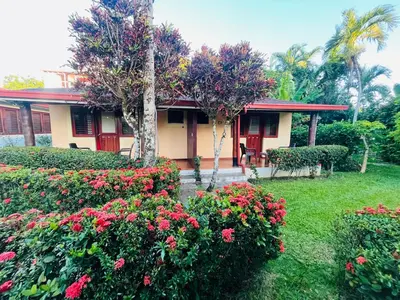 a house with flowers in front of a yard at Hotel palococo in Las Terrenas