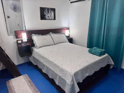 a bedroom with a bed with two lamps and blue floors at enjoy the nature of the countryside in Bonao