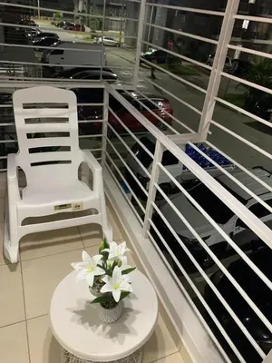 a white chair and a table with flowers on a balcony at Casa Mamá Tere in Pantoja