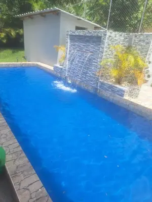 a large blue swimming pool next to a fence at JARABACOA villa Almonte in Jarabacoa