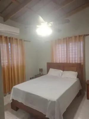 a bedroom with a white bed with a ceiling at JARABACOA villa Almonte in Jarabacoa
