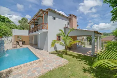 a villa with a swimming pool and a house at JARABACOA villa Almonte in Jarabacoa