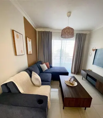 a living room with a blue couch and a table at Apartamento acogedor con estilo y piscina in La Romana