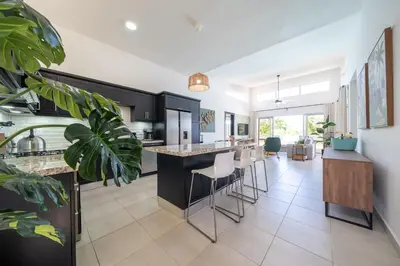 a kitchen with black cabinets and a island with bar stools at Ocean View, Style, Freedom in Sosúa