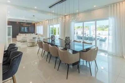a dining room with a glass table and chairs at Casa Deco in La Romana