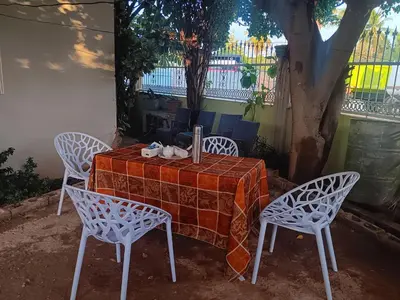 a table with three chairs and a table and a table at Hospedaje Las Flores Pedernales in Pedernales