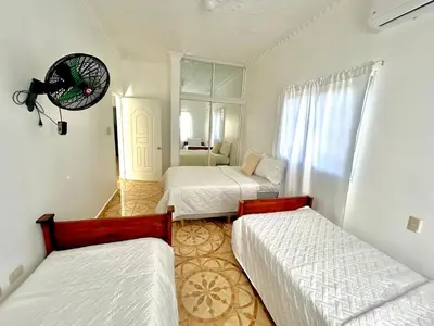 a bedroom with two beds and a room with a window at Villa Rosa 3 Habitaciones Balcones Aire Acondicionado Espacio Ideal Para Tu Familia O Grupo in Río San Juan