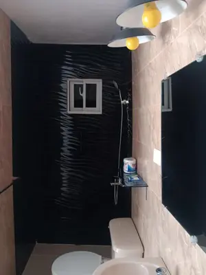 a bathroom with a toilet and a black wall at Hospedaje Las Flores in Pedernales