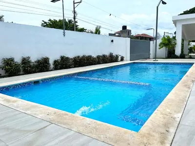 a swimming pool with blue water in a house at Family-friendly apartment near the beach in Boca Chica