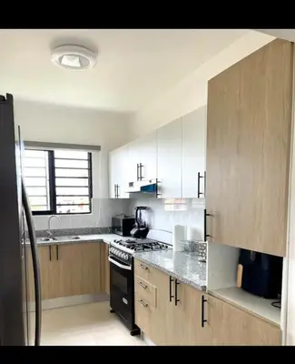 a kitchen with white cabinets and a stove top oven at Residencial JT1 Avenida España in La Viva