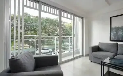 a living room with a couch and a large window at Encanto en gazcue - Cerca del Malecón y la Zona Colonial in Santo Domingo
