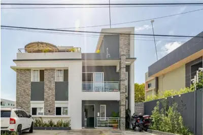 a white car parked in front of a building at Vintage Villa confortable apartments Wifi private pool free parking in Boca Chica