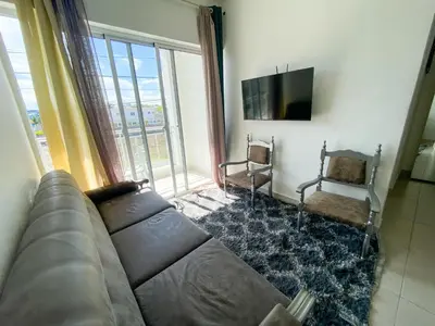 a living room with a couch and a large window at Vintage Villa confortable apartments Wifi private pool free parking in Boca Chica