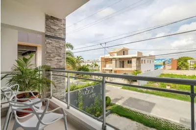 a balcony with a chair and a view of a street at Vintage Villa confortable apartments Wifi private pool free parking in Boca Chica