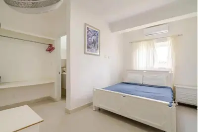 a bedroom with a bed in a white room at Vintage Villa confortable apartments Wifi private pool free parking in Boca Chica