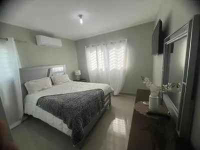 a bedroom with a bed and a window at Moderno y amplio apartamento en Santiago in Carlos Guerra