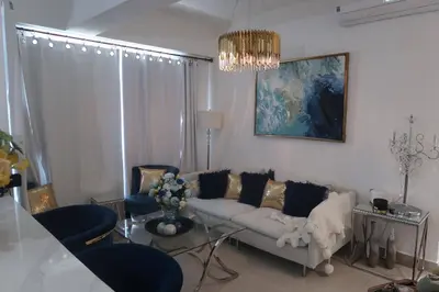 a living room with a white couch and blue chairs at Boca Chica in Boca Chica
