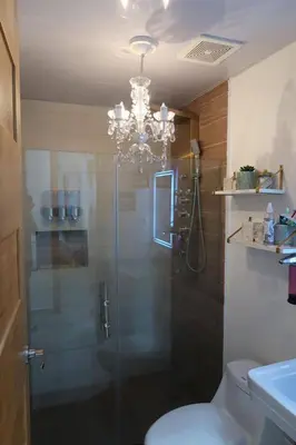 a bathroom with a glass shower with a chandelier at Boca Chica in Boca Chica