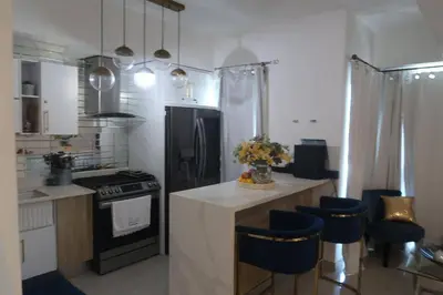 a kitchen with a counter with blue chairs in it at Boca Chica in Boca Chica